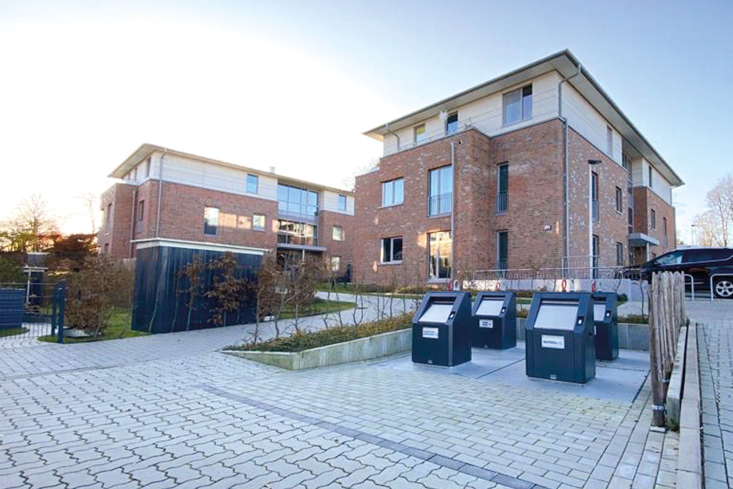Mehrere Halbunterflursysteme vor Mehrfamilienhaus